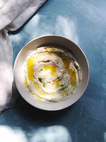 avocado dip in a bowl on a blue counter