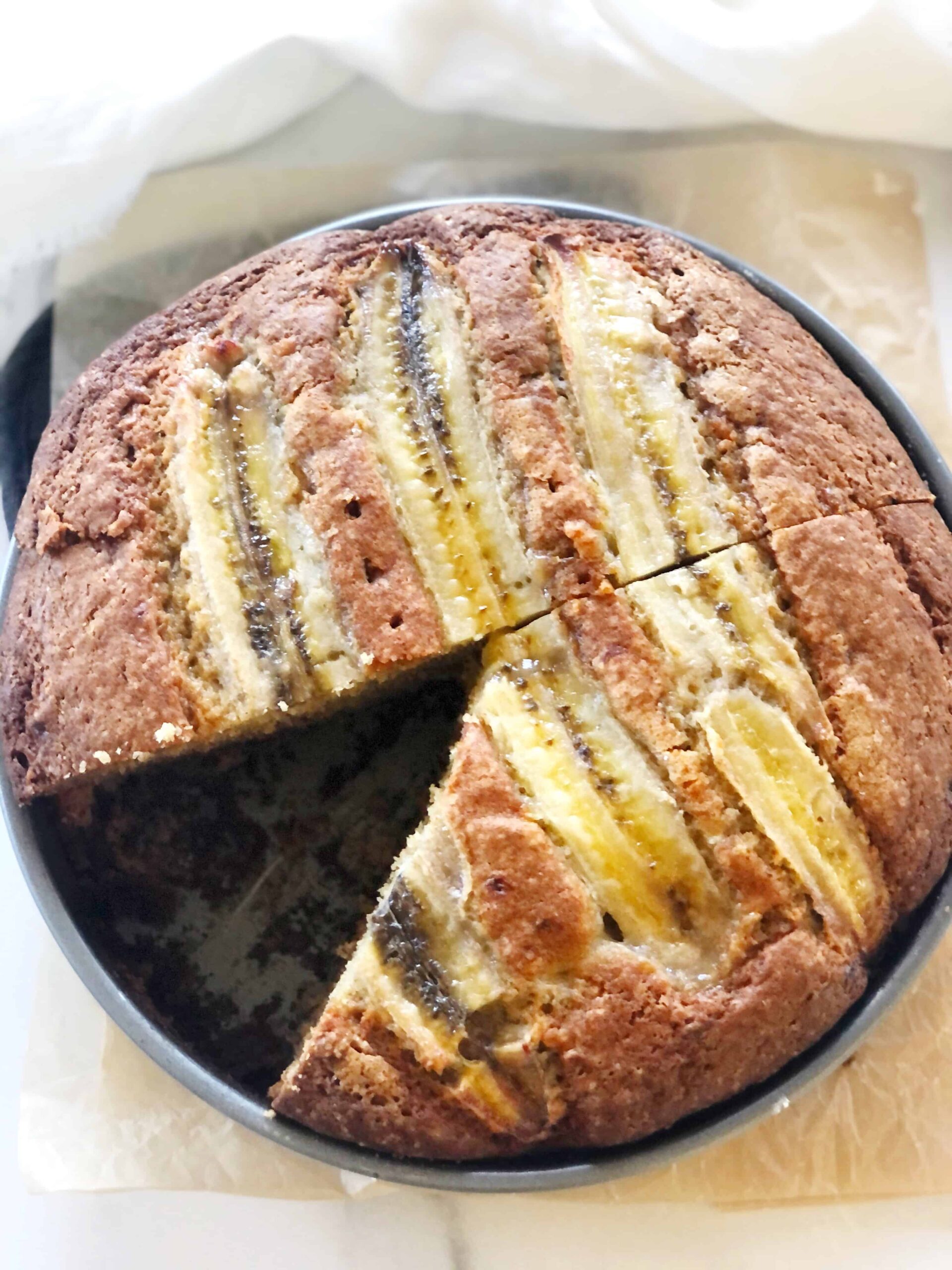 top view of banana bread in a cake pan with a slice cut out