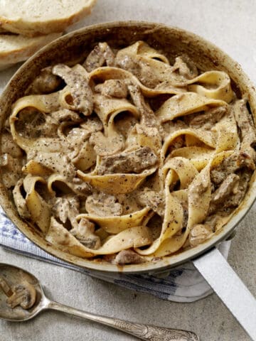 A pan full of pasta with prime rib in it.