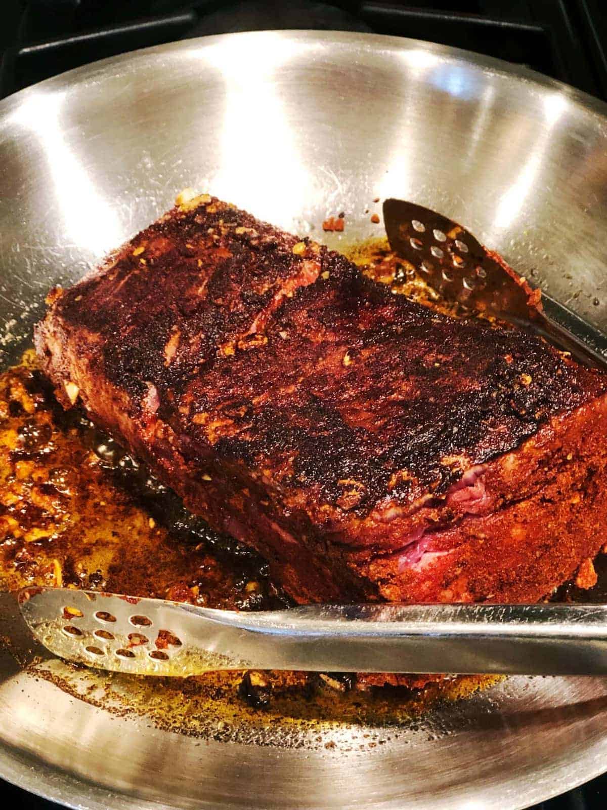 Searing pot roast in a pan.