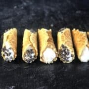 Pizzelle cannoli on a black counter.